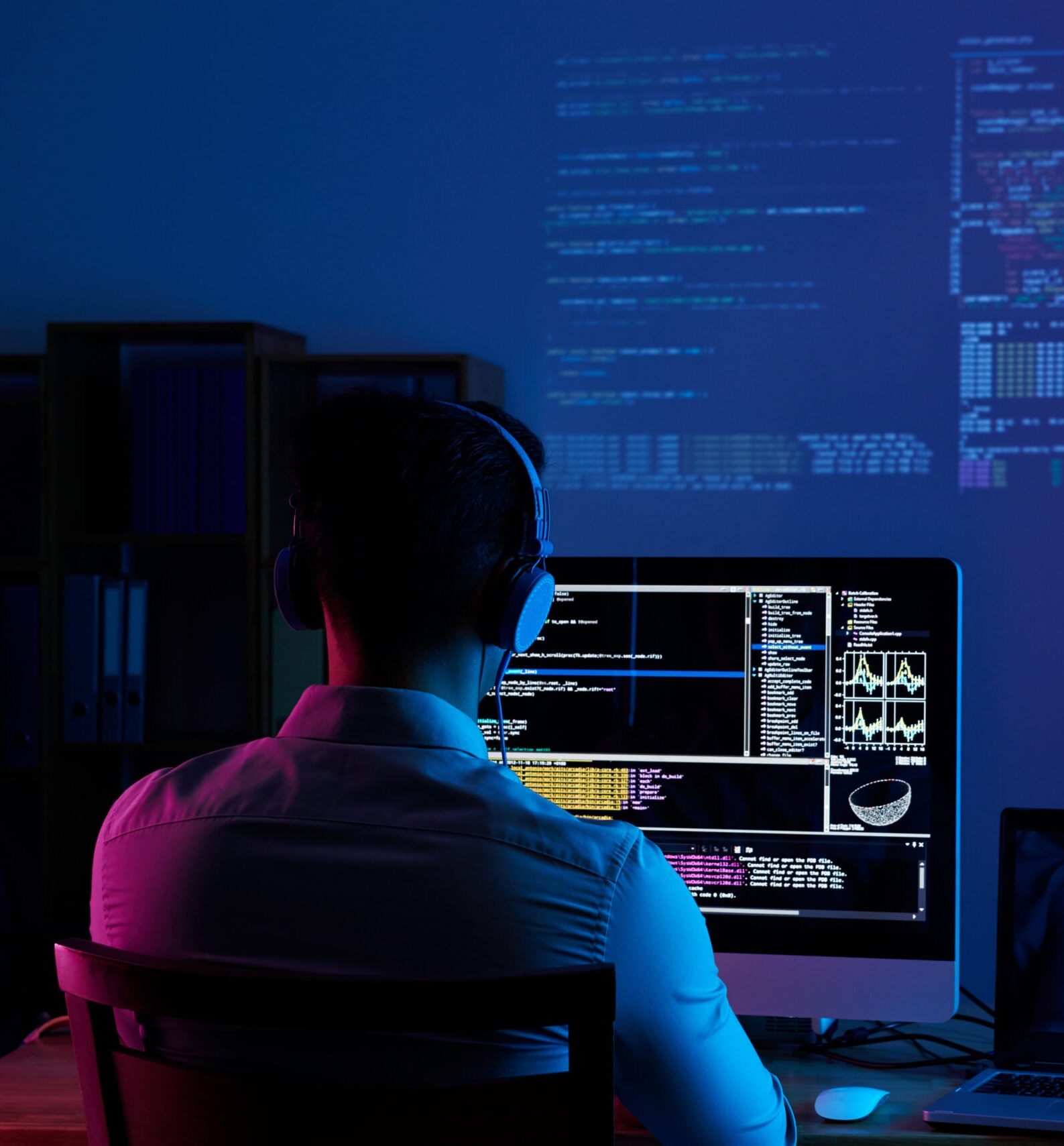 Working all night long Developer working on code late at night, view from the back